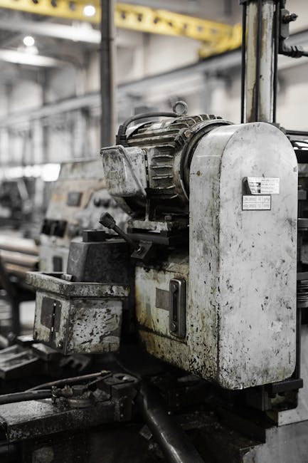 Greasy industrial machinery in a factory showcasing heavy equipment and metalwork.