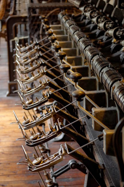 Close-up of antique spinning loom, showcasing intricate metal parts and textile machinery.